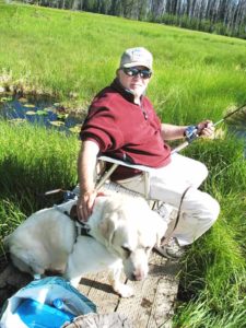 Hal Long with his faithful guide dog, Floyd, on a fishing adventure.