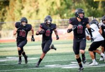 Tualatin football scrapes by in head-to-head with 5A’s finest Senior Malik Ross (8), with aid from AJ Noland (18) and Peter Burke (11), secures an 85-yard touchdown.
