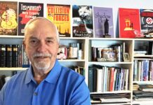 Dave Dehart retires from Army with 20 years military service at age 37, Now using intelligence service experience to write novels for third career Dave in his library which features the books he has authored.