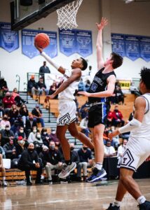 Junior Josiah Lake (14) jumps in for a layup against the 5A challenger, Churchill.