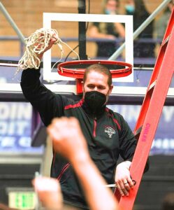 Being the last one to cut the net, Coach Jukkala Holds it up in celebration with the Tualatin fans.
