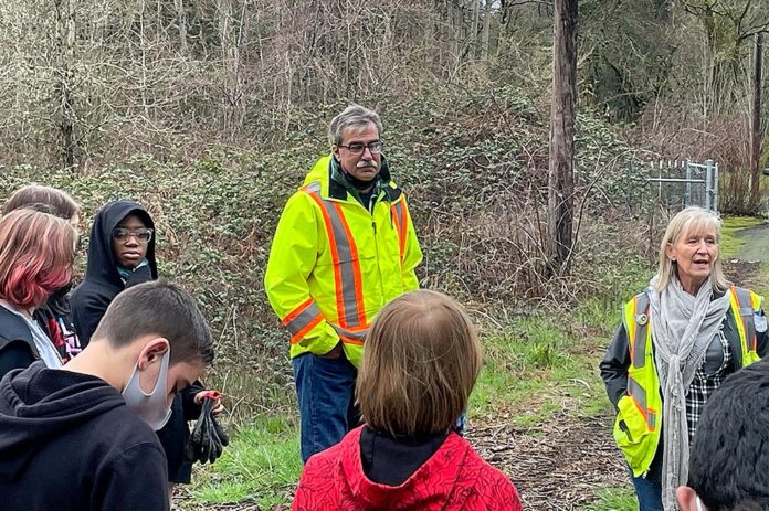 Parks Maintenance Manager Tom Steiger (L) and Parks technician Shelly Helgerson (R) lead Hazelbrook Middle School students through a morning of planting in Jurgens Park