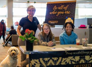Dressed to Dream formalwear giveaway puts the glitz in prom for area teens Event organizer Cyndy Hillier (standing) joins volunteer greeters Keira Morthland (left) and Ellie Emery in welcoming guests to Dressed to Dream