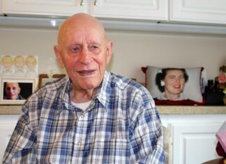 WWII veteran joined the Navy and saw the world Roland Whitely reminisces about his World War II experiences as a gunner on Merchant Marines ships transporting military supplies around the world. Behind him is a photo on a pillow of his beloved late wife of 71 years, Allene. Barbara Sherman/Tigard Life