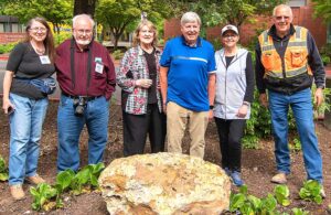 (L-R) Sylvia Thompson, Rick Thompson, Yvonne Addington, Scott Burns, Linda Moholt and Brian Clopton gather in front of the rhyolite erratic that is now on display at the Tualatin Heritage Center.