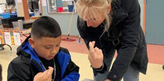 Rotary Helps Tualatin Students Define Success & Service Rotarian Dr. Julie Spaniel practices sign language with a Tualatin Elementary student.