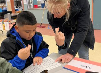 Rotary Helps Tualatin Students Define Success & Service Rotarian Dr. Julie Spaniel practices sign language with a Tualatin Elementary student.