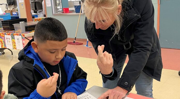Rotary Helps Tualatin Students Define Success & Service Rotarian Dr. Julie Spaniel practices sign language with a Tualatin Elementary student.