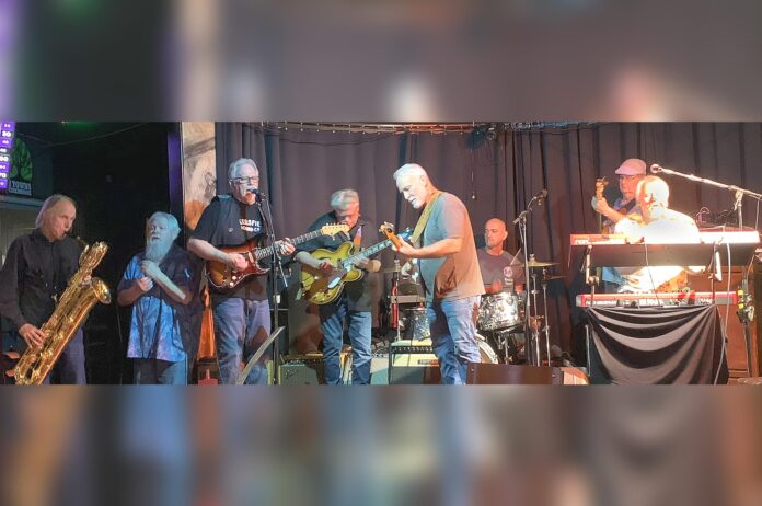 From Left, Pete Moss on sax, George Discant on harmonica, guitarists Ken Scandlyn, Rouke Vanderveen, and Gary Hines, Jimi Bott on drums, Jim Solberg on bass and Ed Neumann on keyboards.