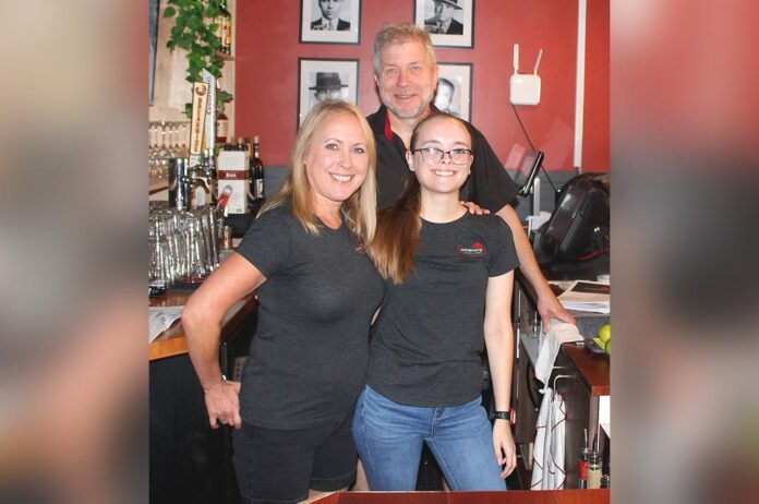 Janelle and Chris Johnson stand behind the bar with her daughter Abby Inkens, who works at the King City restaurant full time.