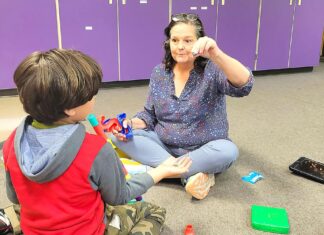 TTSD Makes Big Changes in Autism Services In this photo, Autism Specialist Val Valo uses play-based strategy to support the student’s social and language development. She encourage him to ask for the marbles in her hand as he builds a marble tower.