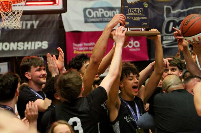 The Tualatin boys basketball team celebrates after winning the state title thanks to a crazy finish that saw the Timberwolves hit two threes in the last nine seconds.