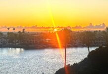 Rays of Light Shining Through A sun set with a ray of light effect overlooking a bay.