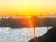 Rays of Light Shining Through A sun set with a ray of light effect overlooking a bay.