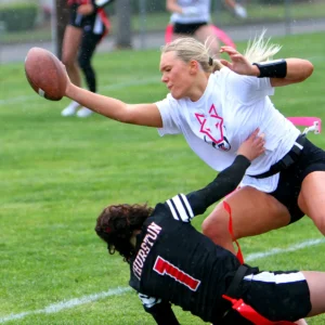 Tualatin senior Ries Miadich takes some contact while stretching toward the end zone in a playoff win against Thurston. 