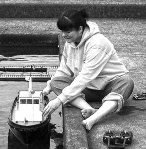 Author Cindy Hinrich with her grandfather's scratch-built tug boat, which she sometimes runs on the pond with my dad