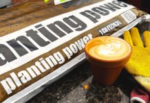 Warning: It Was a Circus Here Today A bag of planting power soil on a counter next to a latte in a clay pot mug and gardening gloves.
