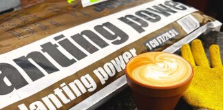 Warning: It Was a Circus Here Today A bag of planting power soil on a counter next to a latte in a clay pot mug and gardening gloves.