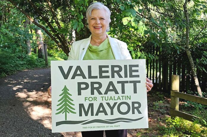 Valerie Pratt holding "Valerie Pratt for Mayor" sign.