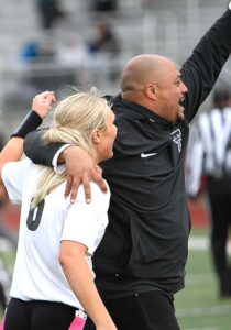 Bubba Lemon hugs quarterback Ries Miadich after winning a state title in flag football in the program's second year.
