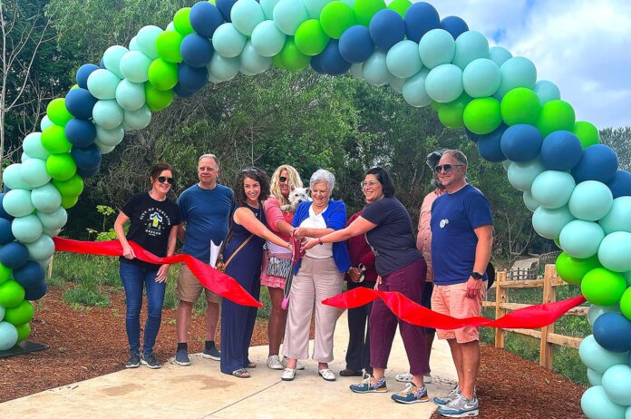 Nyberg-Creek-Trail-Ribbon-Cutting Tualatin City Councilor Valerie Pratt, surrounded by other key project planners like Tualatin East CIO President Doug Ulmer, cuts the ribbon at the Nyberg Creek Trail grand opening on Saturday, June 20.