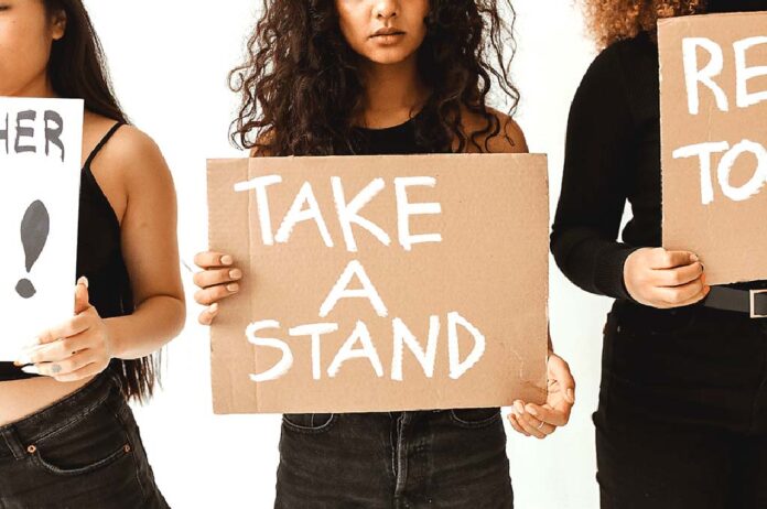 Women holding Take A Stand Signs