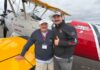 Tualatin Vets Fly Over Aurora in Vintage WWII Planes Bill Manderfeld and pilot Marcus Smith stand in front of a WWII-era plane that flew local veterans out of Aurora State Airport.
