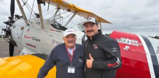 Tualatin Vets Fly Over Aurora in Vintage WWII Planes Bill Manderfeld and pilot Marcus Smith stand in front of a WWII-era plane that flew local veterans out of Aurora State Airport.