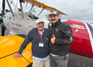 Tualatin Vets Fly Over Aurora in Vintage WWII Planes Bill Manderfeld and pilot Marcus Smith stand in front of a WWII-era plane that flew local veterans out of Aurora State Airport.