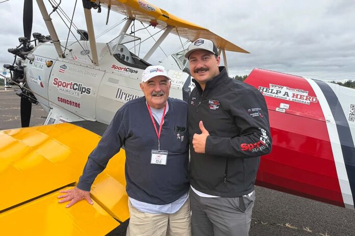 Bill Manderfeld and pilot Marcus Smith stand in front of a WWII-era plane that flew local veterans out of Aurora State Airport.