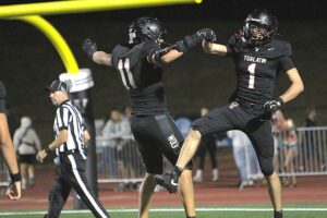 Hunter Grubb (No. 1) and Zane Carley (No. 11) celebrate after Grubb hauled in a nearly 70-yard-touchdown pass in Tualatin's 52-13 win to open the season.