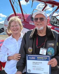 Veteran Larry Wittmayer holds his commemorative Dream Flights boarding pass alongside pilot Molly Littlefield.