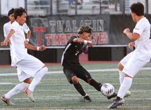 Tualatin's Cesar Venegas splits the defenders and fires a near-miss on goal in a 0-0 tie to open the season. 