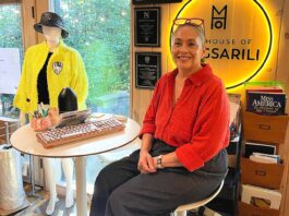 Tualatin Fashion Designer Weaves Stories into Her Work Magsarili sits in front of her neon House of Magsarili sign at her home/office space.