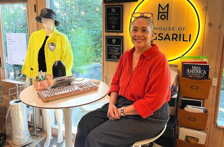 Tualatin Fashion Designer Weaves Stories into Her Work Magsarili sits in front of her neon House of Magsarili sign at her home/office space.