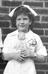Susan Noack as a child playing dress-up.