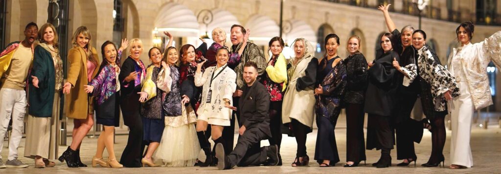 Tualatin fashion designer Generosa Magsarili (center, in white) poses in Paris during Paris Fashion Week in September 2024 alongside her team of 18 non-professional models, ranging in age from 17 to 62. The historic outdoor photo session followed Magsarili's first ever runway showcase in the global fashion capital for her brand, The House of Magsarili.