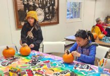 Winona Grange set to Host Annual Harvest Festival Oct. 24 Two people carving pumpkins at a table.