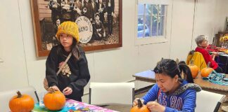 Winona Grange set to Host Annual Harvest Festival Oct. 24 Two people carving pumpkins at a table.
