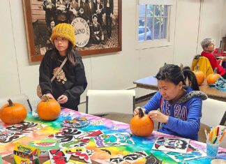 Winona Grange set to Host Annual Harvest Festival Oct. 24 Two people carving pumpkins at a table.